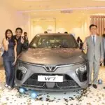 Group celebrating around new VF7 car.